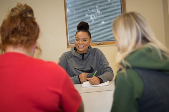 A communications major speaking to two other students